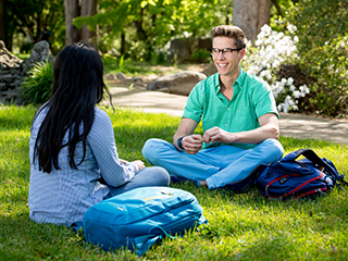 Southern Adventist University students sitting on campus lawn